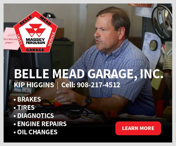 Mechanic at garage desk with service signage