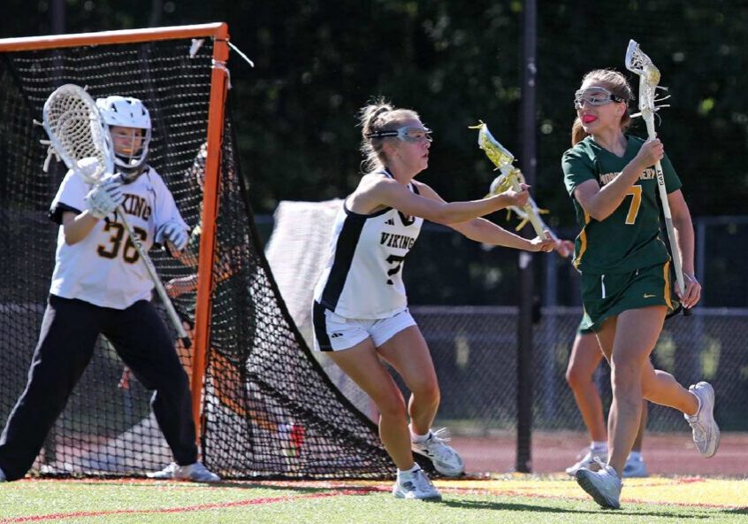 Attacker evading defender near lacrosse goal