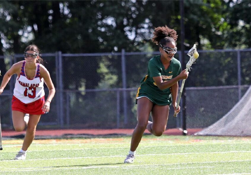 Lacrosse player in green pursued by opponent