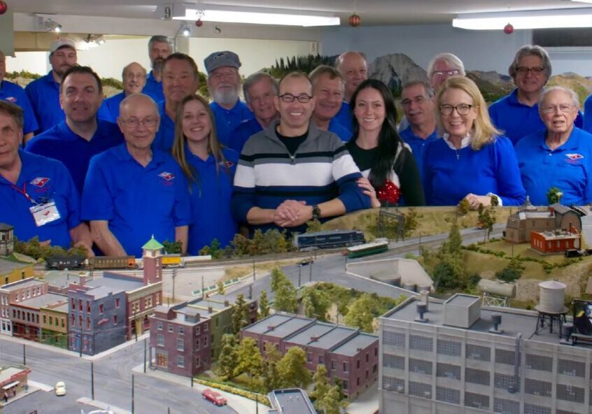 Group of people behind model train layout