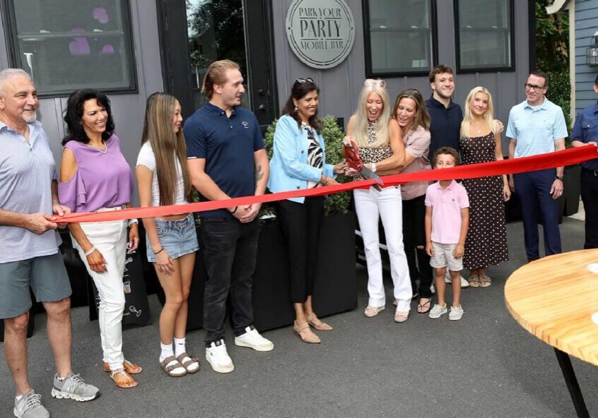 People cutting ribbon at storefront opening
