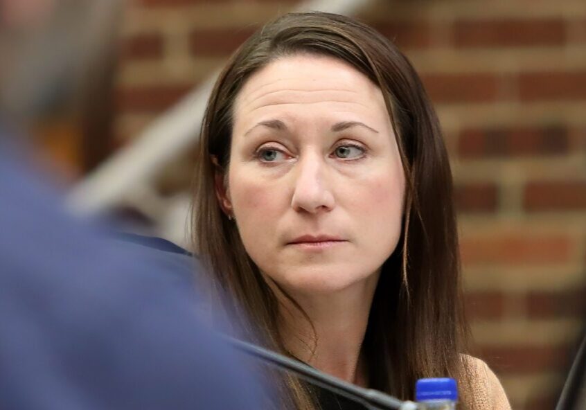 Woman in hearing room looking to side