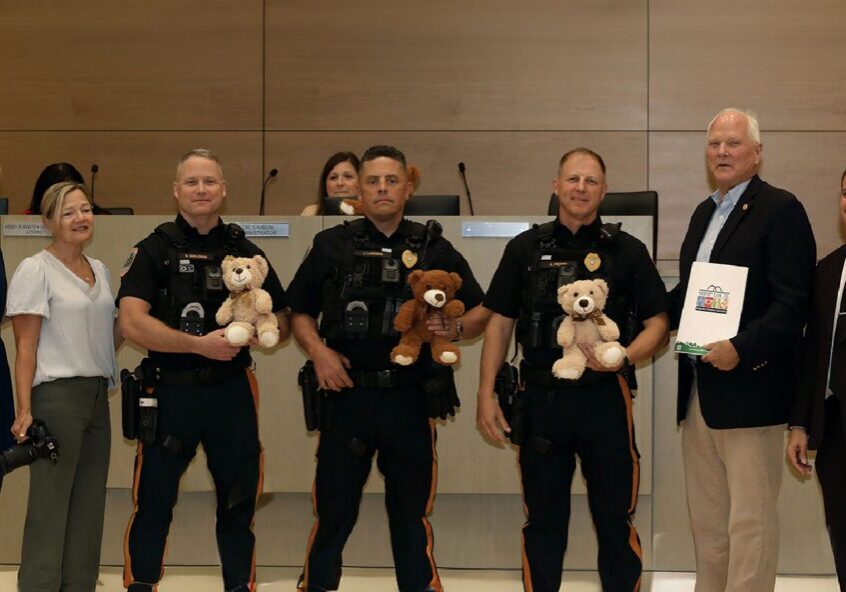 Police officers and officials holding teddy bears